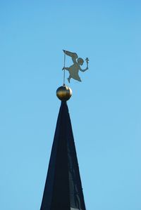 Low angle view of weather vane against clear blue sky