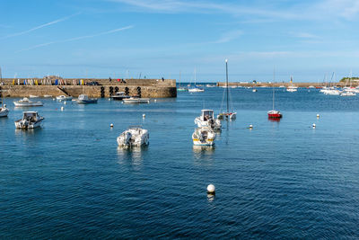 Sailboats in sea against buildings in city