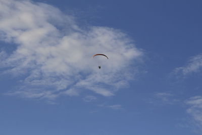 Low angle view of person paragliding against sky