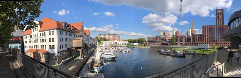 Panoramic view of buildings against cloudy sky