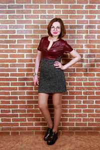 Portrait of a smiling young woman standing against brick wall