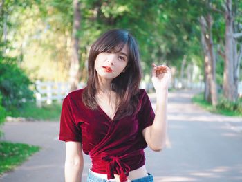 Portrait of beautiful young woman holding red camera