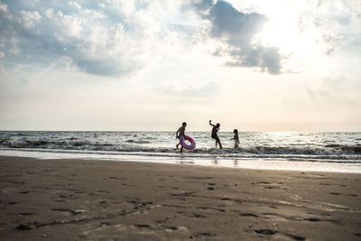 People on beach against sky