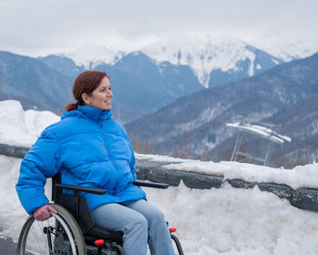 Portrait of man sitting on snowcapped mountain