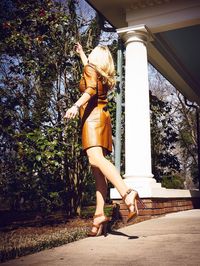Woman standing on tree trunk