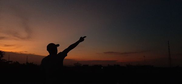 Silhouette people standing against sky during sunset