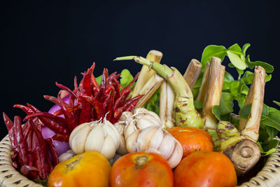 Close-up of tomatoes and chili peppers against black background