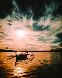 Silhouette boat in sea against sky during sunset