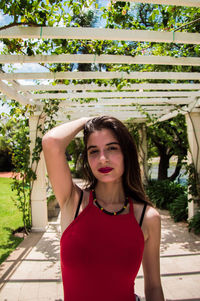 Portrait of a beautiful young woman standing against plants