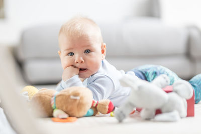 Portrait of cute baby boy lying on bed at home