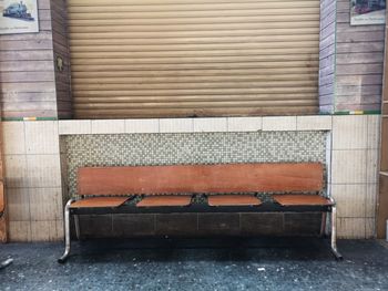 Empty bench against wall