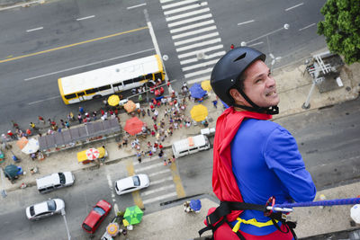 Man dressed as a superhero rappelling down from a tall building. salvador bahia brazil.