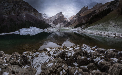 Scenic view of lake by mountains against sky