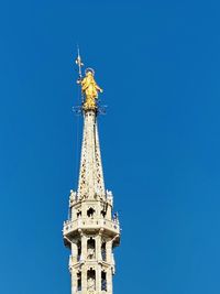 Low angle view of tower against blue sky