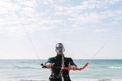 Portrait of man standing in sea against sky