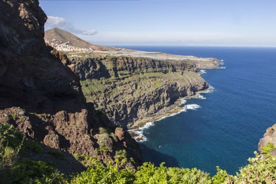 High angle view of rocks by sea against sky