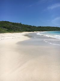 Scenic view of beach against clear blue sky