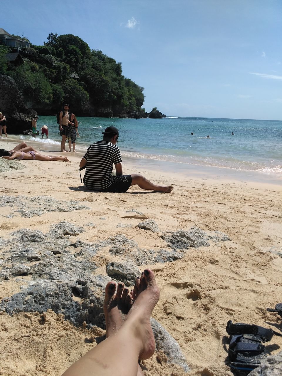 LOW SECTION OF PEOPLE SITTING ON BEACH