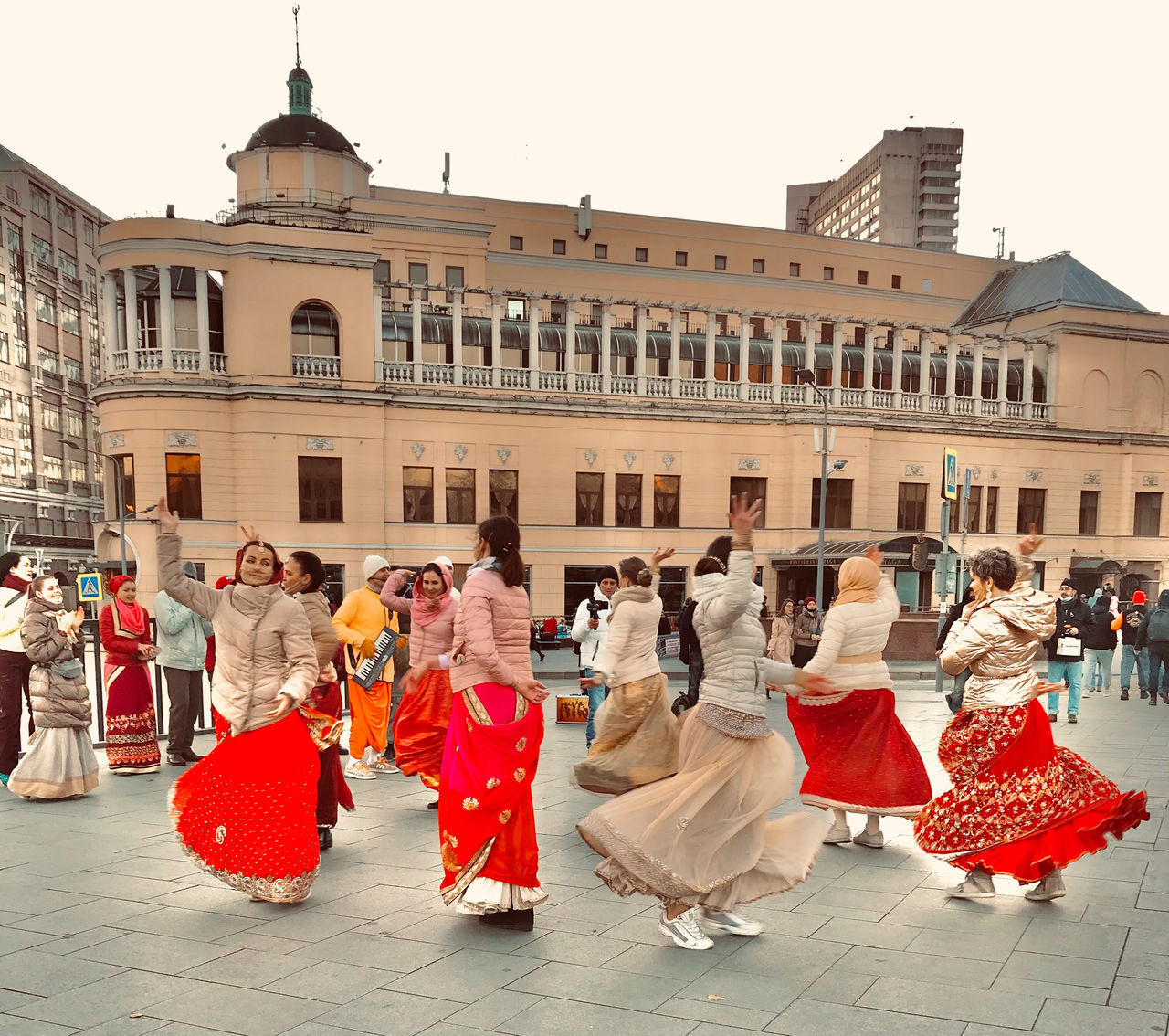 GROUP OF PEOPLE WALKING ON STREET AGAINST BUILDINGS