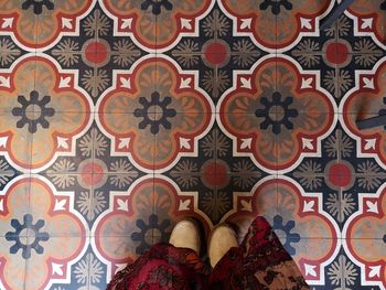 Low section of woman standing on tiled floor