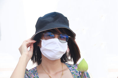 Portrait of woman wearing sunglasses against white background