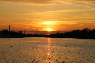 Scenic view of lake against orange sky