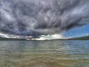 Scenic view of sea against storm clouds