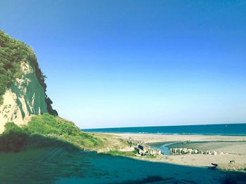 Scenic view of beach against clear blue sky