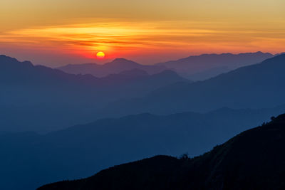 Scenic view of silhouette mountains against sky during sunset