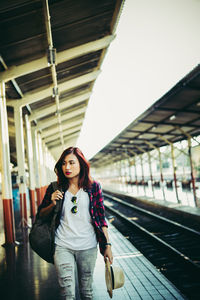 Young woman walking at railroad station platform
