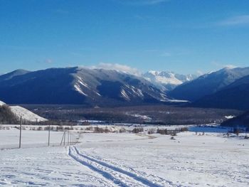 Scenic view of snowcapped mountains against blue sky