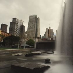 Buildings in city against cloudy sky
