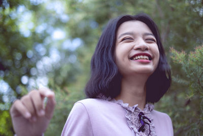 Portraits smiling asian young girl with pine tree in vintage color.