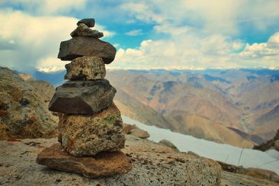 Stack of rocks on mountain against sky