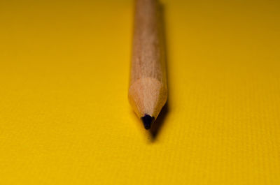 Close-up of pencil against yellow background
