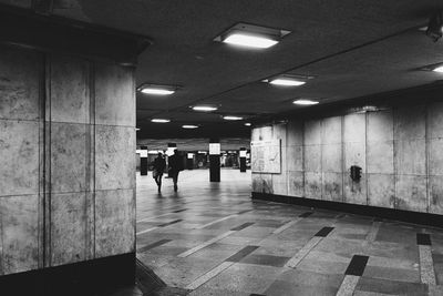 Woman walking in illuminated corridor