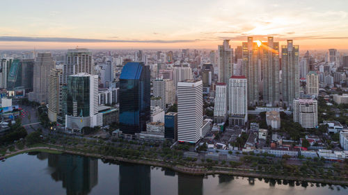 Reflection of buildings in city at sunset