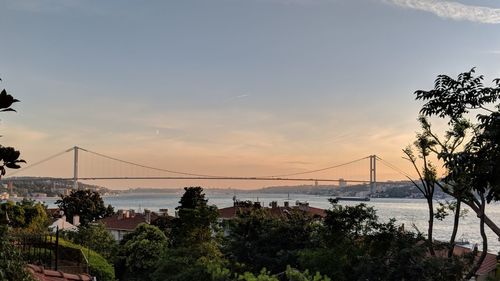 Bridge over sea against sky during sunset