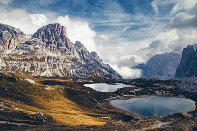 Scenic view of lake by mountains against sky