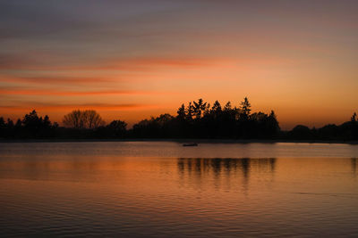 Scenic view of lake against orange sky
