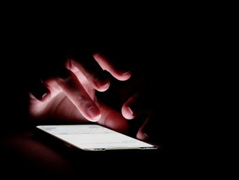 Close-up of person hand on book in darkroom