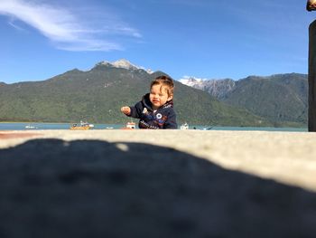 Portrait of boy in water against sky