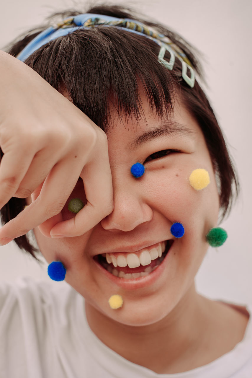 headshot, portrait, real people, happiness, child, one person, childhood, lifestyles, close-up, front view, smiling, emotion, leisure activity, indoors, women, human body part, teeth, innocence, hairstyle, mouth open, bangs, human face