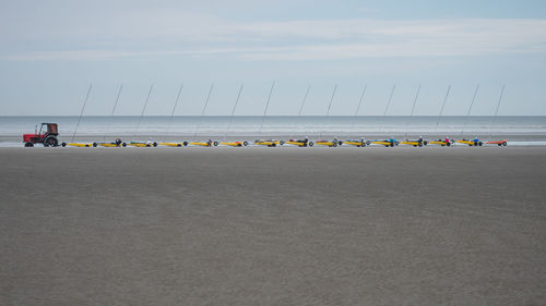 People on beach against clear sky. sand yachts, its lolking great.