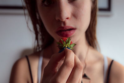 Close-up of woman holding strawberry