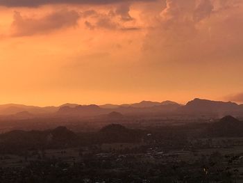 Scenic view of silhouette mountains against orange sky