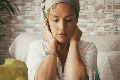 Portrait of young woman sitting on sofa at home