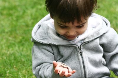 Cute toddler with worm in palm