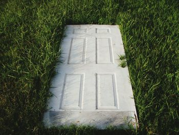 High angle view of abandoned door on grassy field