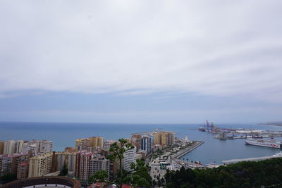 High angle view of city by sea against sky